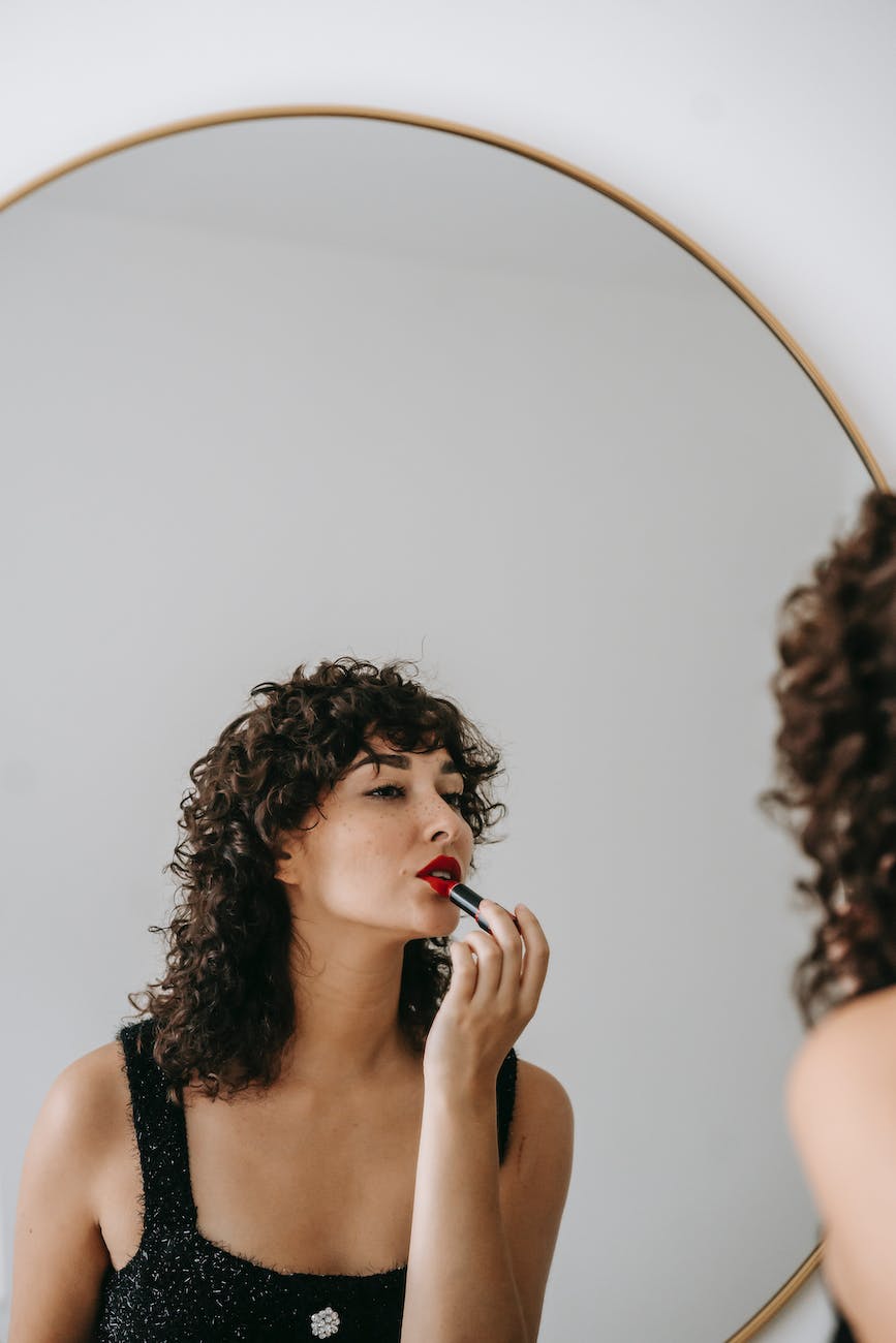 photo of woman applying red lisptick